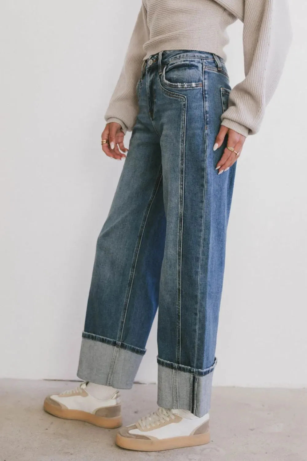 Wide leg cuff jeans with buttoned pockets, no stretch, cotton-polyester blend.