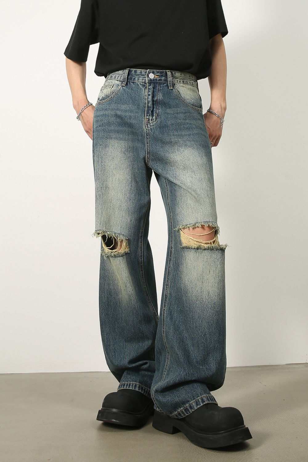 Men's distressed baggy jeans with raw hem detailing and no stretch fabric.