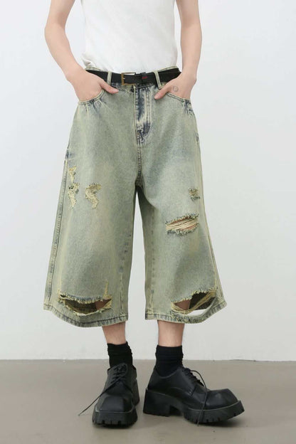 Men's distressed loose denim shorts with ripped details, basic style.