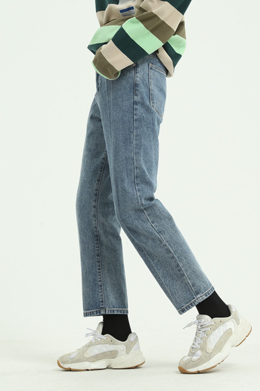 Straight leg jeans with pockets in denim, worn with sneakers.