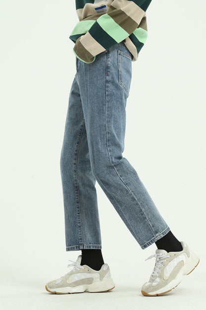 Straight leg jeans with pockets in denim, worn with sneakers.