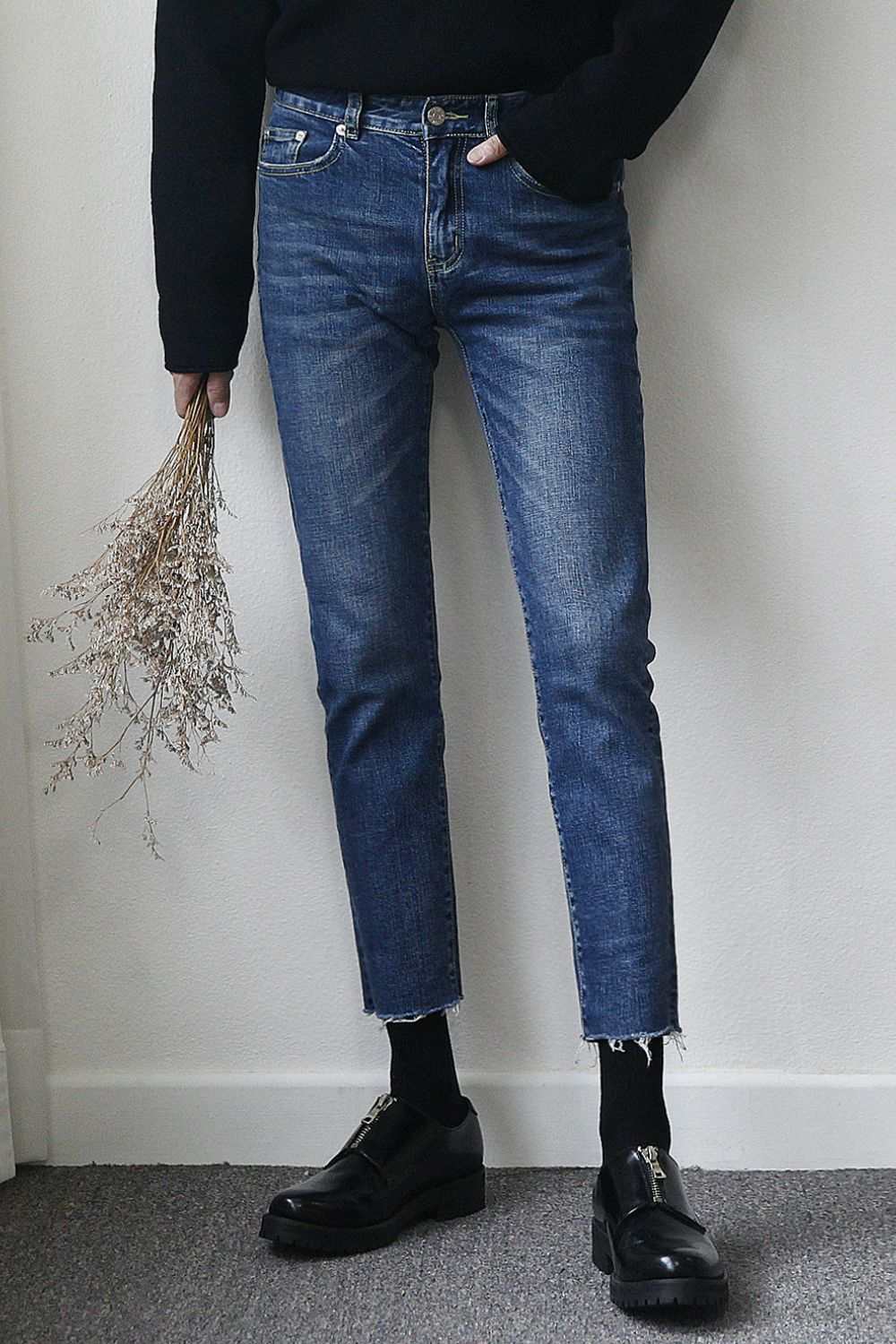 Men's frayed hem skinny jeans with slightly stretchy fabric, featuring basic style.
