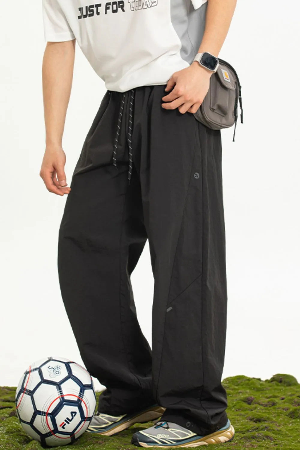 Men's plus size drawstring loose fit pants in black, modeled with casual attire and soccer ball.