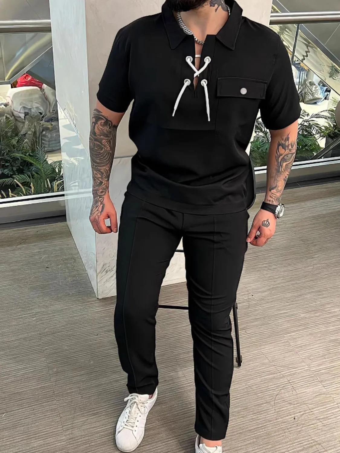 Men's full size black lace-up short sleeve top and pants set.