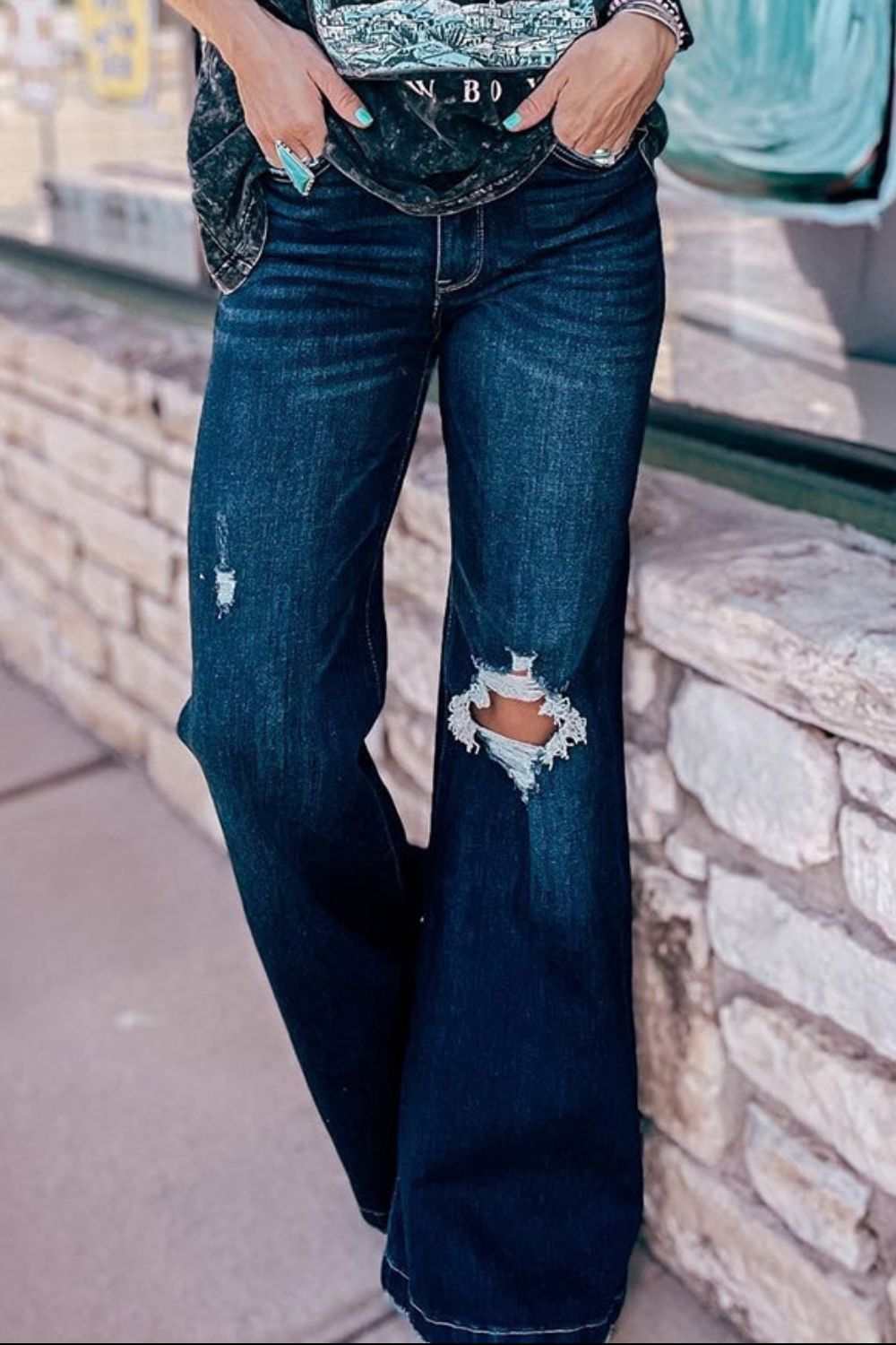 Distressed wide leg jeans with pockets showcasing torn details.