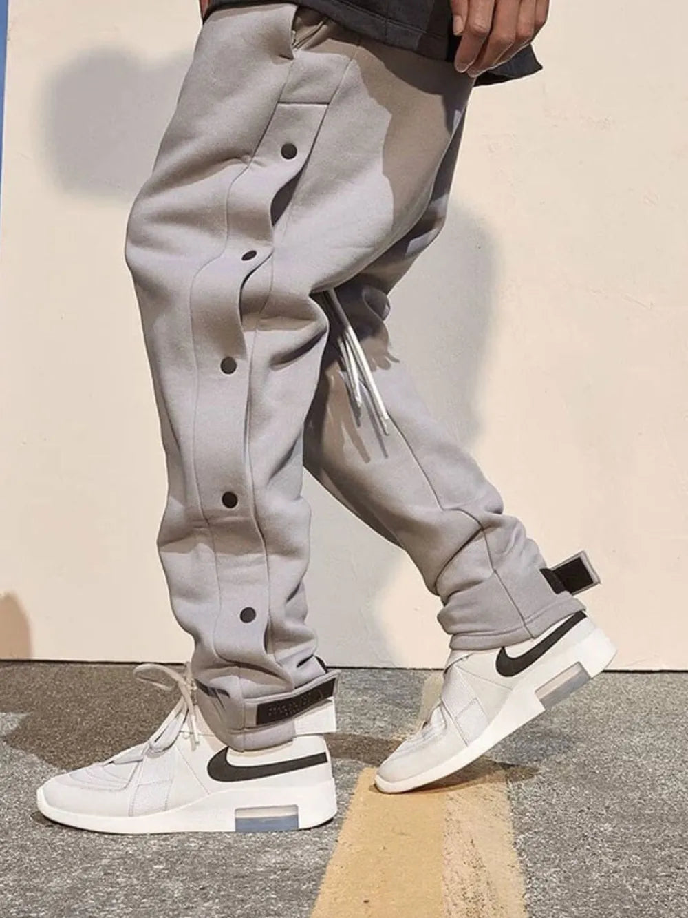 Men's side button pants in gray, featuring buttoned design and relaxed fit.