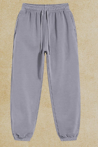 Men's drawstring joggers with pockets made of cotton-polyester blend.