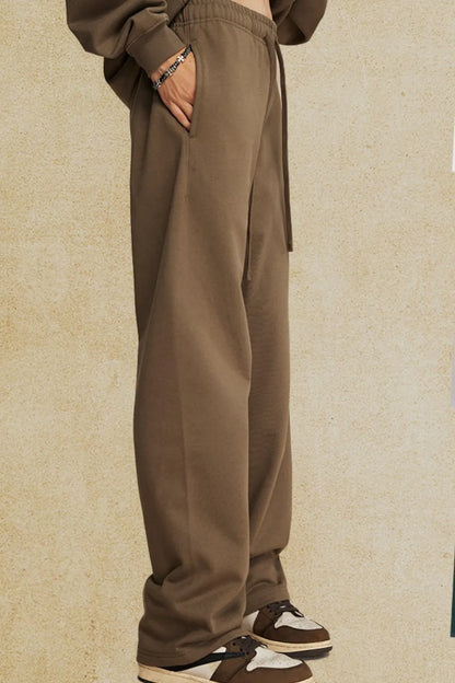 Men's drawstring loose fit pants in brown with side pockets, featuring a comfortable and relaxed style.