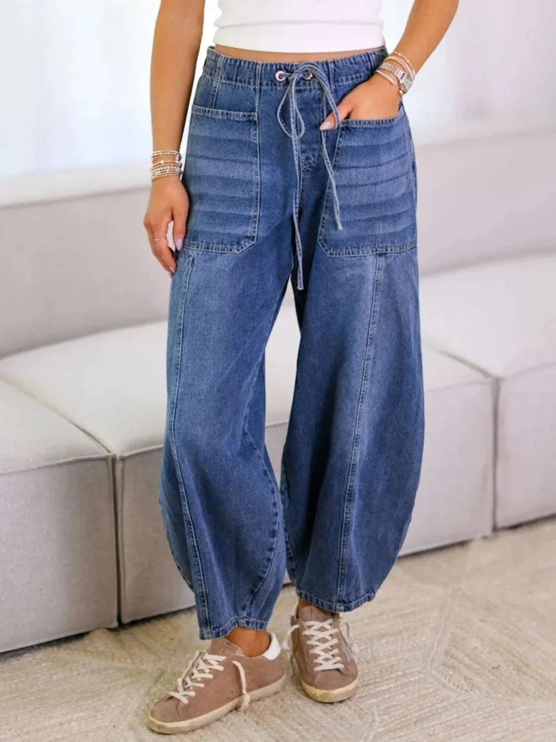 Tied wide leg jeans with pockets, buttoned detail, and no stretch, made from a cotton-polyester blend.