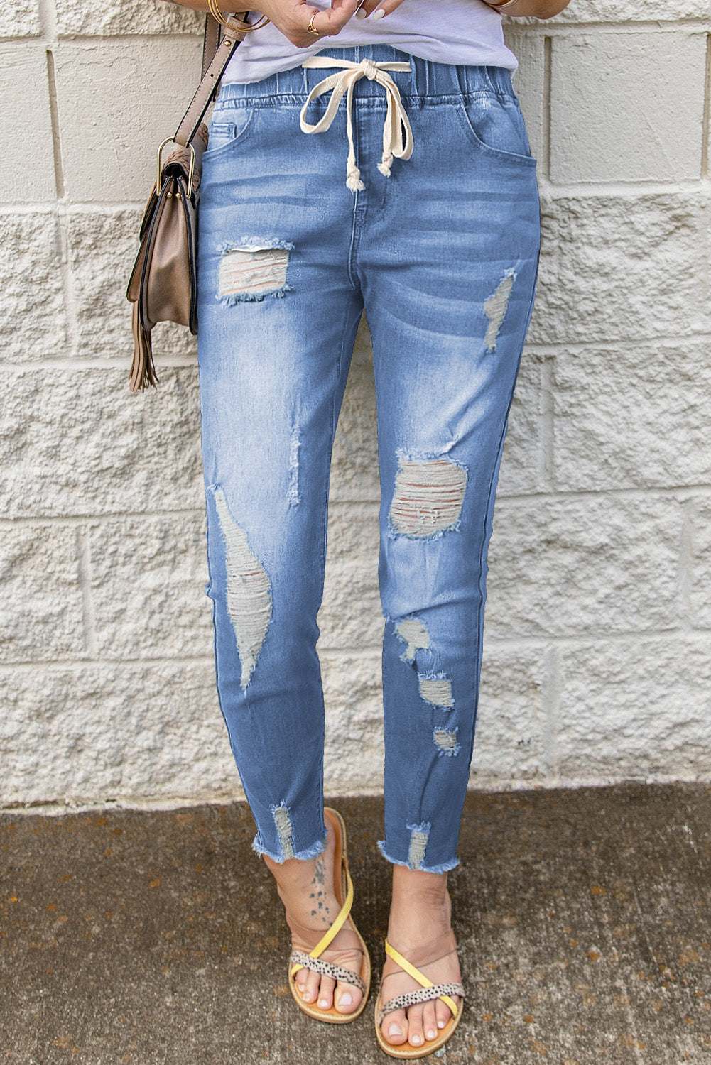 Drawstring distressed raw hem jeans with pockets, featuring ripped details.