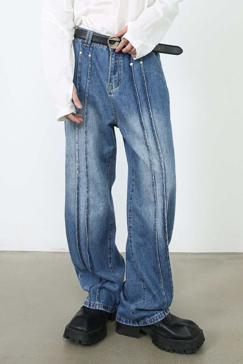Men's loose fit jeans in blue denim, basic style, no stretch, worn with black belt and shoes.