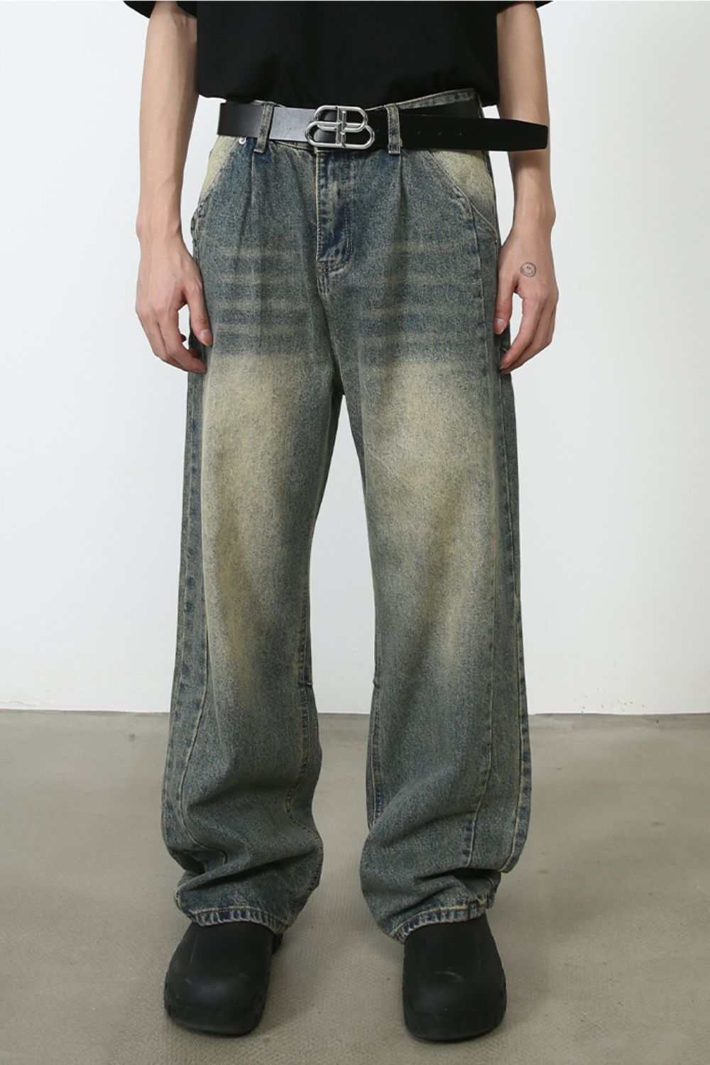 Men's wide leg jeans with no stretch, machine washable, worn with a black belt and shoes.