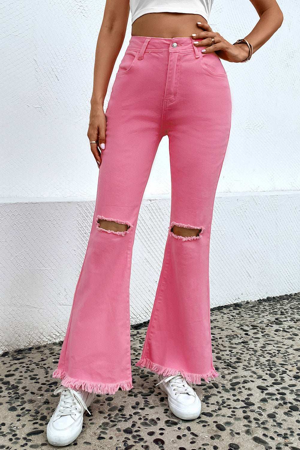 Distressed raw hem bootcut jeans with slightly stretchy fit in pink.