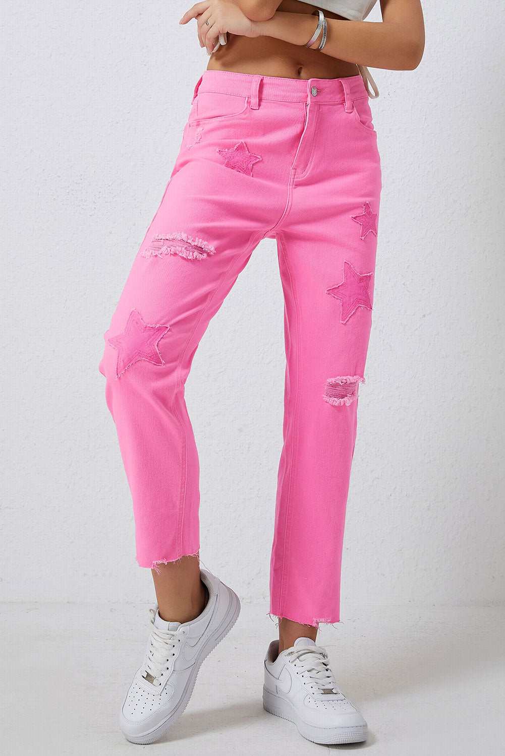 Pink star raw hem distressed jeans with slight stretch, featuring star patterns and a casual fit.