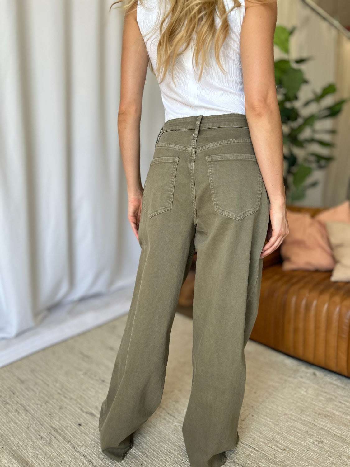 Wide leg jeans in garment-dyed green with a high-rise fit, featuring a relaxed silhouette and raw hem.