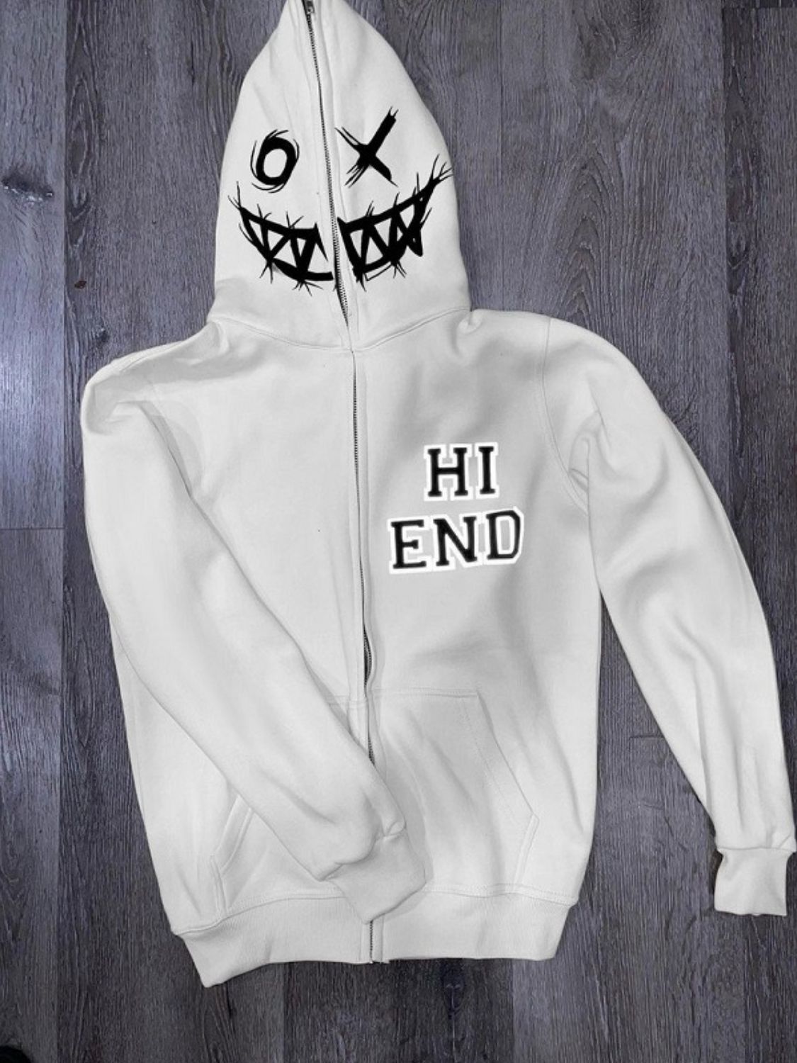 Men's zip up letter graphic hoodie with playful stitched face design on hood, pocketed, polyester and cotton blend.