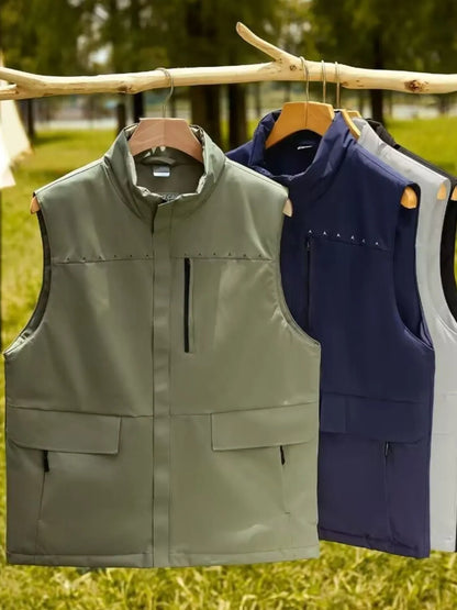 Men's full size zip up vests in multiple colors hanging on a wooden rack outdoors.