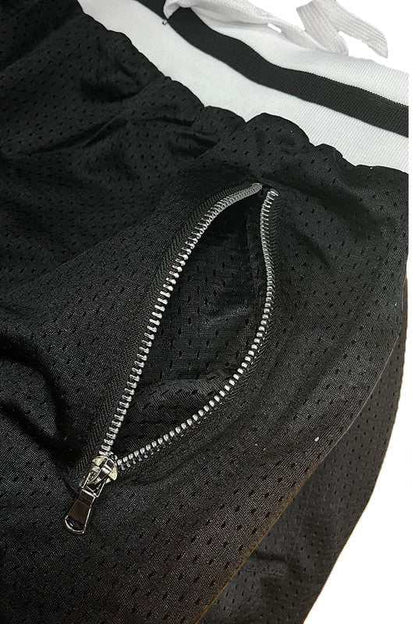 Solid basketball shorts with striped band, mesh fabric, and zippered pocket.